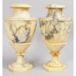 A PAIR OF ALABASTER URN SHAPED VASES on octagonal bases. 1ft 1ins high.