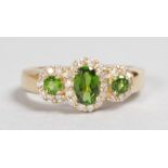 A LOVELY 14CT YELLOW GOLD, GREEN GARNET AND DIAMOND CLUSTER RING.