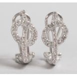 A LOVELY PAIR OF WHITE GOLD AND DIAMOND KNOT SHAPED EARRINGS.