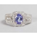 A LOVELY 14CT WHITE GOLD, TANZANITE AND DIAMOND CLUSTER RING.