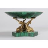 A SMALL ITALIAN MALACHITE CIRCULAR TAZZA, 5.5ins diameter, on gilt dolphin supports on a base