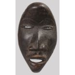 A SMALL AFRICAN CARVED WOOD MASK. 6ins long.