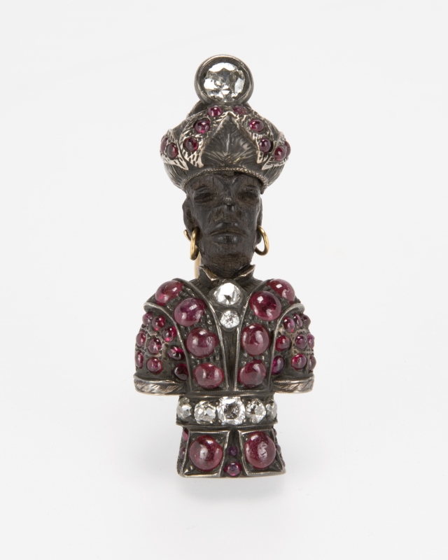 An antique ebony, ruby, diamond blackamoor brooch