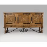 A relief-carved oak and iron Belgian sideboard