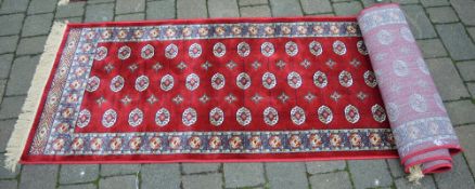 Red ground Kashmir runner with a bokhara