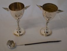 2 silver plated cups flanked with ornate