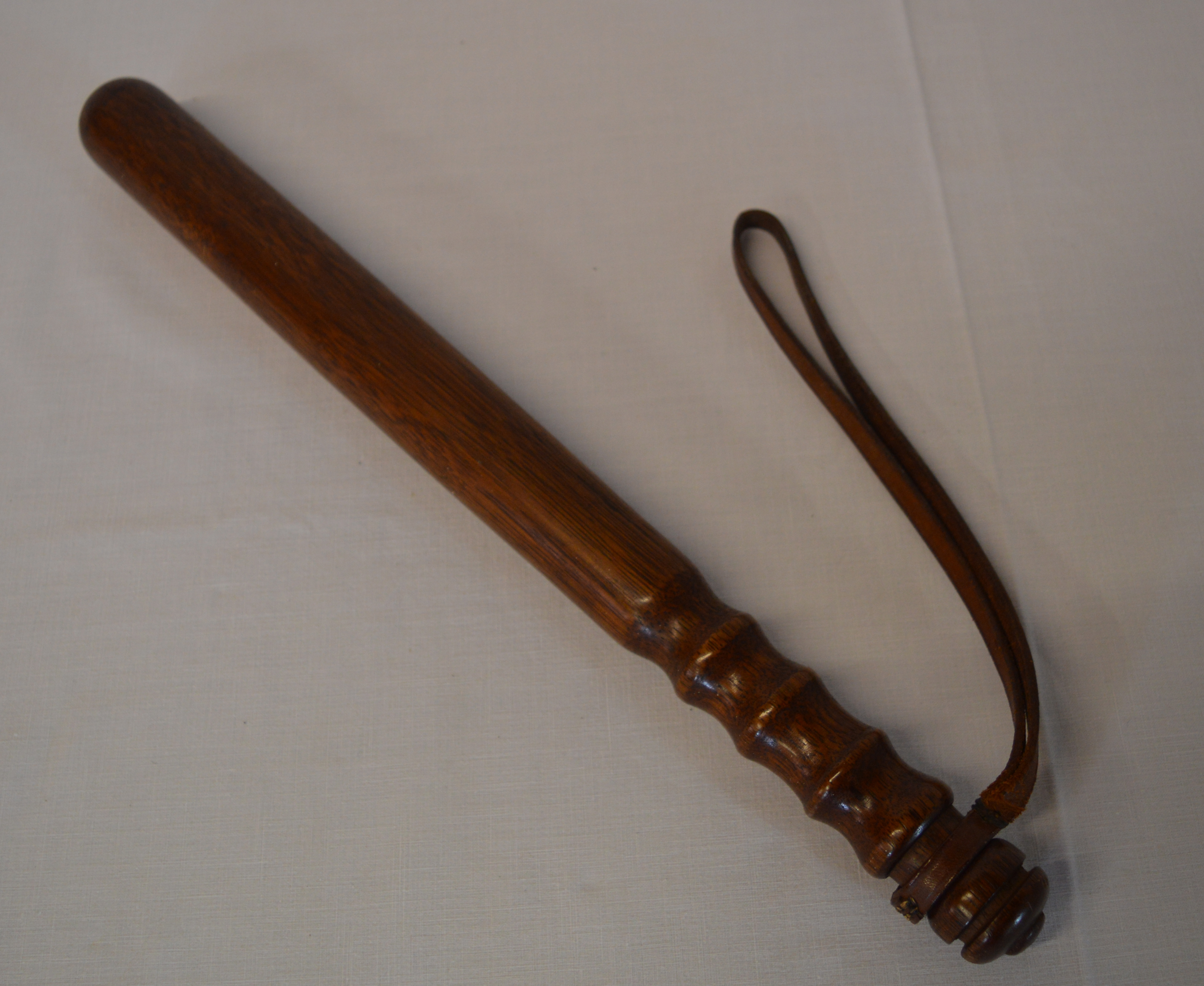 Truncheon with turned grip and a leather