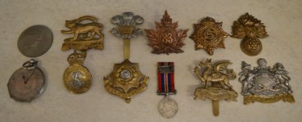 Various military cap badges including Le