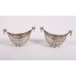 A pair of Indian white metal boat-shaped dishes with cast foliate decoration and mask and ring