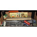 A quantity of Hornby O gauge track, a clockwork locomotive and tender, two trucks, an oil tanker,