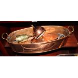 An oval copper fish kettle, sides embossed salmon, 24" long, a brass bottle jack and hanger and a