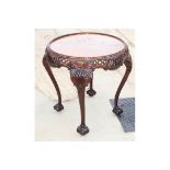 A mahogany circular occasional table with later inset flame mahogany top, carved and pierced frieze,