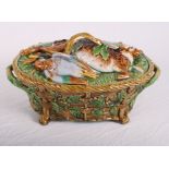 An oval majolica pie dish, lid decorated dead game, sides moulded basketwork and oak leaves, 14"