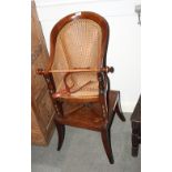 A child's 19th Century mahogany bergere high chair, on stand fitted sabre supports