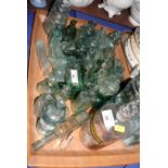 A collection of green glass inkwells and other small bottles