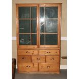 A 19th Century pine haberdashery cabinet, the upper section enclosed sliding glazed doors, fitted