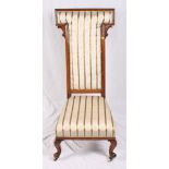 A Victorian mahogany framed prie dieu chair with tall "T"-shaped back and stuffed over seat