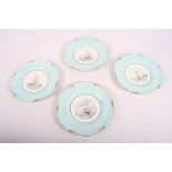 A set of four Royal Crown Derby wall plates decorated pale blue and gilt borders, centres painted