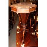 A Victorian rosewood work table with hinged top enclosing fitted interior and well, on tripod base