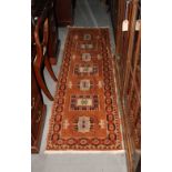 A Heriz peach ground rug, 78" x 24" approx