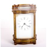 A carriage clock in gilt brass case with serpentine sides and plain white enamel dial, 5" high