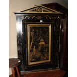 An ebonised wall hung corner cabinet enclosed panelled door decorated gilt with oriental figure in a