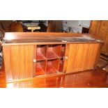 A walnut wall cupboard of pigeonholes enclosed by a tambour shutter, 36" wide