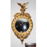 A Regency convex wall mirror in ball decorated frame with eagle surmount, 44" high