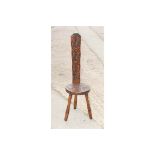 A spinning chair with narrow carved back and circular carved seat, on three turned supports