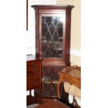 A George III mahogany two-stage corner cabinet with shaped front shelves enclosed astragal beaded
