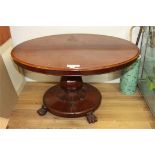 A Victorian mahogany oval tilt top dining table, on octagonal baluster stem and circular base fitted