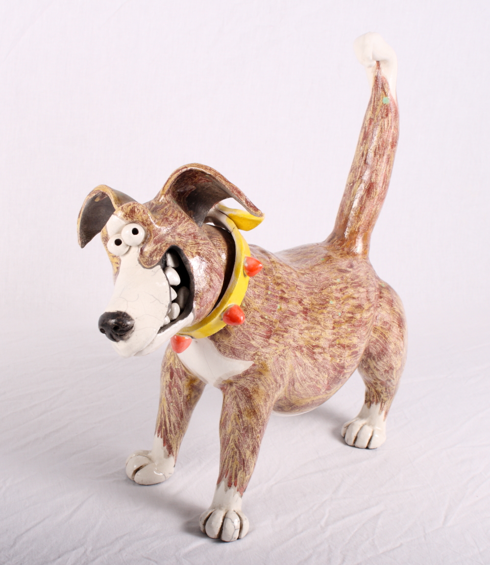 A humorous pottery sculpture of a dog, monogrammed "A J", 13" high