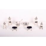 A pair of silver pepper pots, two silver mustard pots and a plated four-piece cruet set