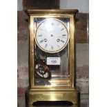 A brass framed mantel clock with bevelled glass sides, white enamel dial, 10 1/2" high