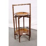 A polished as walnut folding cake stand with two brown cloud glass plates, a folding two-division