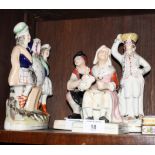 A pair of Staffordshire figures of a cobbler and his wife, a similar watch group and another