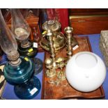 An embossed brass firescreen, two pairs of brass candlesticks, a brass oil lamp, etc