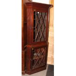 A George III mahogany two-stage corner cabinet with shaped front shelves enclosed astragal beaded