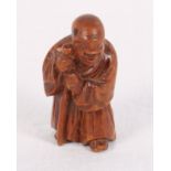 A 19th Century Japanese Meiji period carved fruitwood netsuke formed as a Senin