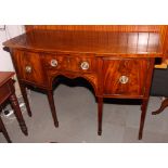 A George III mahogany bowfront sideboard, fitted central drawer and two cupboards, on six square