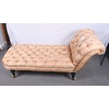 A Victorian settee with single scroll end, upholstered in a pink striped fabric, on turned