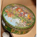 A Huntley & Palmers biscuit tin, lid decorated Kate Greenaway garden party scene with risque