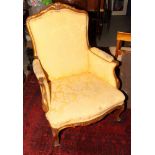 A carved walnut and parcel gilt armchair of Louis XVI design, on cabriole supports