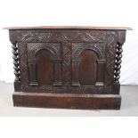 A 19th Century dark stained oak side cabinet with carved front enclosed two arched panel doors,