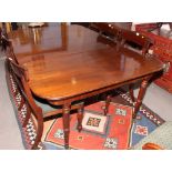 An early 19th Century mahogany two-section dining table with centre leaf, on turned supports,