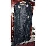 A 1960s black velvet cape with decorative metal clasp