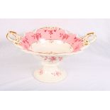 A 19th Century two-handled pedestal fruit comport decorated in pink and gilt