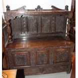 A mule chest with hinged top, carved front with three panels and two drawers, later carved canopy