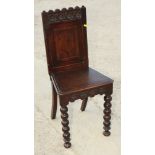 A Victorian 17th Century design dark stained oak hall chair with panelled back decorated escutcheon,