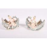 A pair of 19th Century continental bonbon dishes with attendant figures, 5 1/2" high (slight chips